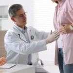 Gastroenterologist examining patient with stomach pain in clinic